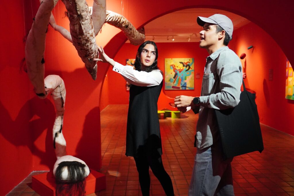 Emma Segura mostrando su obra a visitante